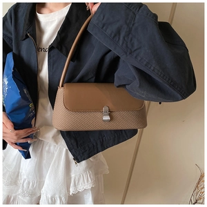 Détail du sac baguette vintage marron en patchwork avec fermoir en métal sur un modèle