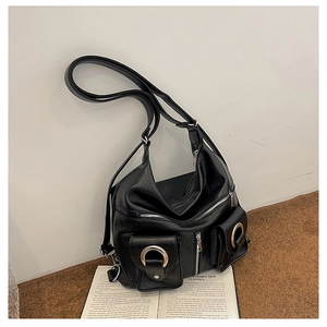 Detail of black faux leather tote with silver rings and multiple functional zip pockets