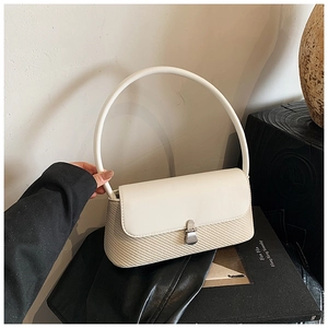 Détails des coutures, rabat en cuir et grande poignée semi-circulaire de ce sac à main chic