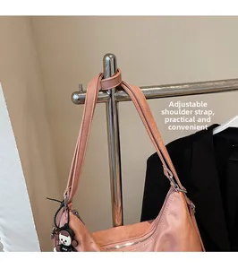 Detail of pink matte tote bag featuring an adjustable shoulder strap and metal zipper closure