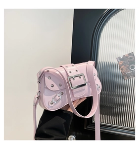 Detail of light pink patent leather shoulder bag with silver studs and large metal buckle
