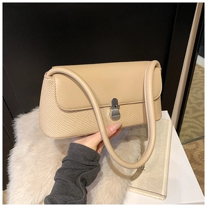 Détail du sac beige avec tissu tissé texturé et rabat en cuir lisse élégant