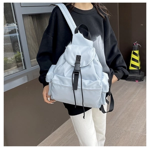 Side view of a light blue nylon casual backpack with buckle straps and drawstring detail