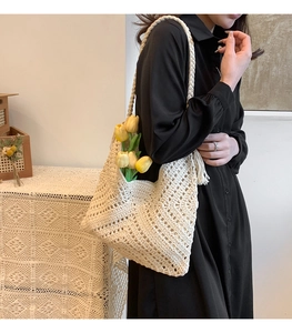 Détail du sac à bandoulière en crochet crème avec motifs géométriques et pendentif à pampilles