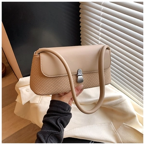 Détail du sac beige avec texture tressée, rabat en cuir et boucle métallique argentée