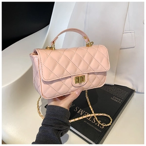 Detailed macro view of pink patent leather quilted bag with gold metal twist lock