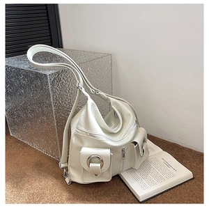 Detail of white lychee grain leather tote bag with silver zippers and utility pockets