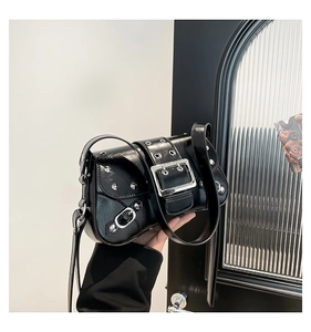 Detail of black punk shoulder bag with silver metal rivets and decorative buckles