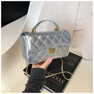 Detail of silver quilted patent leather handbag with gold twist lock and chain strap