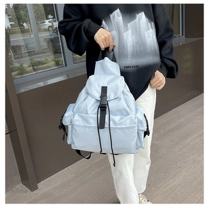 Detail view of the light blue backpack with durable buckle closure and front zip pocket