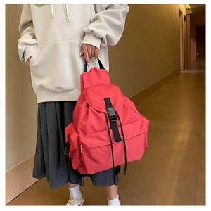 Detailed view of the large rose red nylon backpack featuring secure black buckle and side pockets