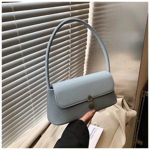 Détail du sac sous le bras bleu clair avec tissage texturé et patchwork de cuir lisse