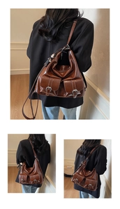 Detail view of vintage brown oiled leather tote bag with functional front buckled pockets