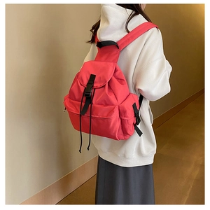 Detail of coral red large capacity backpack with black buckles on casual casual backpack