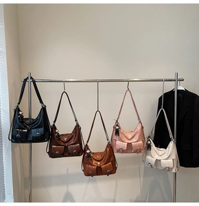 Detail view of five colors of vintage leather tote bags with multi-pockets and bear charms
