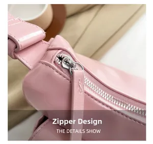 Close-up of the silver metal zipper and stitched leather puller on a pink shoulder bag