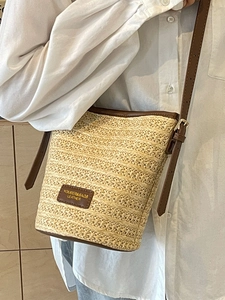 Secchiello chic in paglia intrecciata con finiture in pelle marrone e tracolla regolabile