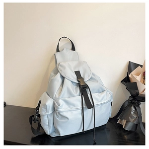 Detail view of the light blue fashion backpack with durable buckle closure and side pocket