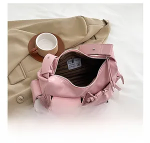 Detail view of pink oil wax leather shoulder bag with striped lining and inner zipper pocket