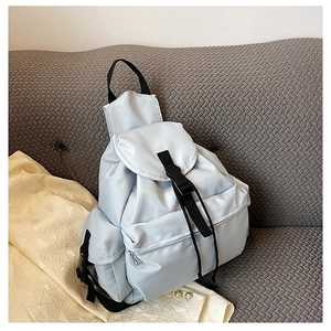Detail of light blue waterproof nylon backpack featuring black buckle closure and front pocket