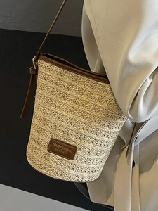 Borsa a secchiello in paglia con finiture in pelle marrone scuro e tracolla stile minimal