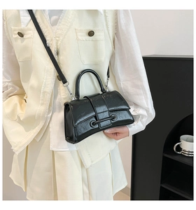 Detail showing the black vintage wrinkled texture and silver rings of the handbag