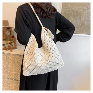 Détail du sac bandoulière blanc au crochet avec texture ajourée et gland sur un modèle