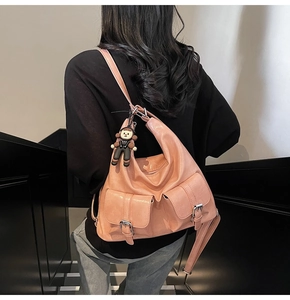 Detail of pink faux leather tote bag showing large front pockets and silver buckles