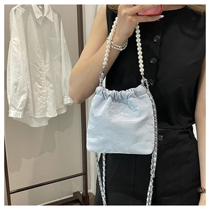 Details der hellblauen Plissee-Beuteltasche mit Perlengriff und Metallketten-Schultergurt