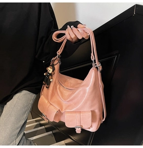 Detail of pink oil wax leather tote bag with functional pockets and bear charm