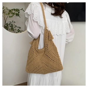 Gros plan détaillé du sac cabas au crochet kaki avec pompon à franges et texture tricotée