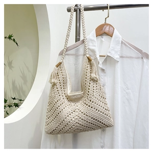 Gros plan du sac au crochet artisanal crème avec motifs bohèmes géométriques évidés