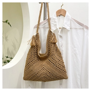 Détail du sac cabas en paille tissé à la main avec motif crocheté et glands