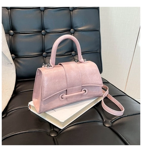 Detailed view of the pink hourglass small handbag on a stylish black leather backdrop