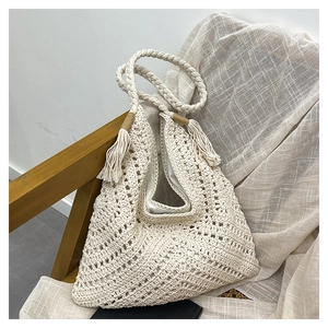 Détail du motif ajouré au crochet et des franges sur le sac cabas tissé beige