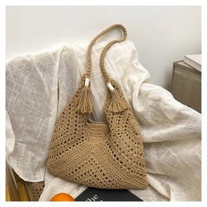 Gros plan détaillé du sac tissé kaki avec texture crochetée ajourée et doubles glands