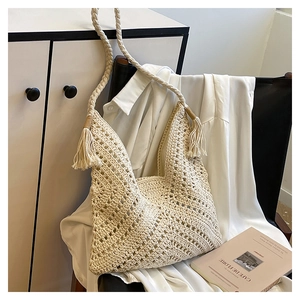 Détail du sac cabas bohème en crochet crème avec tissage évidé et pompons sur le côté
