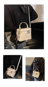 Detail view of the elegant beige box bag showing its smooth texture and stylish strap