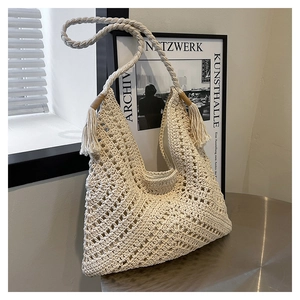 Détail du sac à bandoulière tissé creux avec bandoulière tressée et glands
