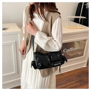 Detail of black faux leather biker crossbody bag with multi-pocket functional design