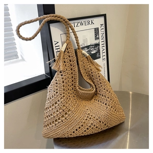 Vue détaillée du tissage au crochet et du gland décoratif sur ce sac de plage beige élégant