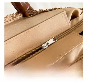 Gros plan du sac cabas en paille tissée avec fermeture éclair en métal et couture