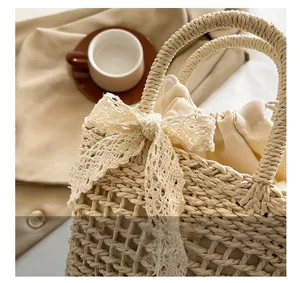 Close-up of woven straw bag with white lace bow detail and drawstring liner