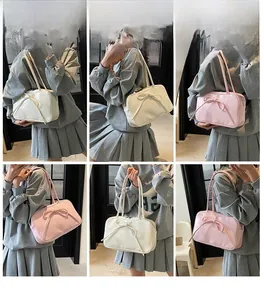Detail showing white and pink bow-tie shoulder bags with sleek glossy finish on models