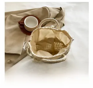 Top view of woven beige beach bag showing interior drawstring liner and lace edge detail