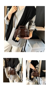 Detailed views of dark brown patent leather Boston bag with plush bear charm and strap
