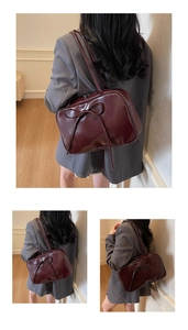 Detail showing the ribbon bow design on a dark burgundy faux leather shoulder bag