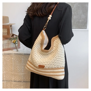 Detail view of woven shoulder bag with leather strap and decorative wood beads