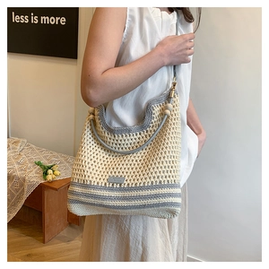 Detail of hand-woven hollow mesh tote bag with wooden beads and contrast stitching