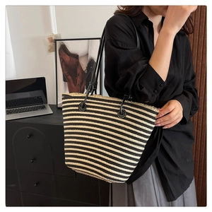 Détail du sac cabas tissé à rayures avec bords effilochés et fines bretelles en cuir noir